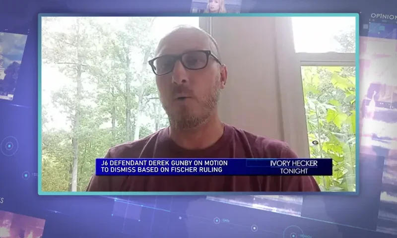 Video still from Ivory Hecker Tonight on One America News Network showing a split screen of the host on the left side, and on the right side is the guest, Derek Rugby.