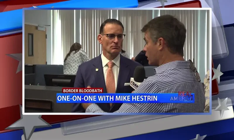Video still from Real America on One America News Network during an interview with the guest, Mike Hestrin.