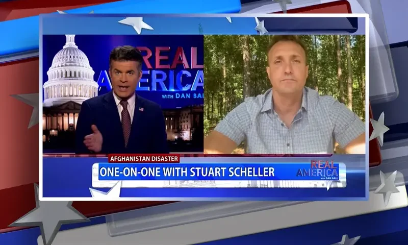 Video still from Real America on One America News Network showing a split screen of the host on the left side, and on the right side is the guest, Stuart Scheller.