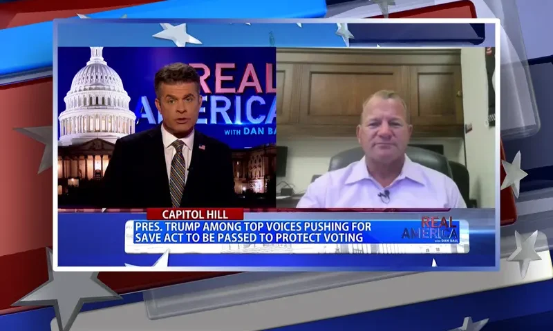 Video still from Real America on One America News Network showing a split screen of the host on the left side, and on the right side is the guest, Rep. Troy Nehls.