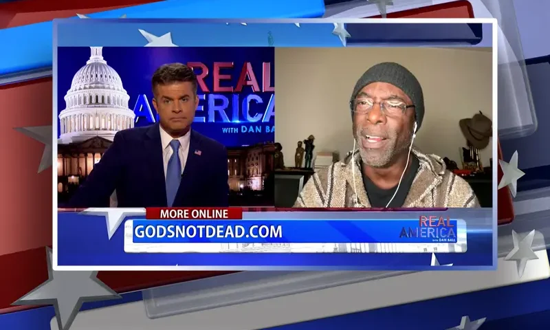 Video still from Real America on One America News Network showing a split screen of the host on the left side, and on the right side is the guest, Isaiah Washington.