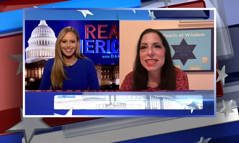 Video still from Real America on One America News Network showing a split screen of the host on the left side, and on the right side is the guest, Cindy Grosz.