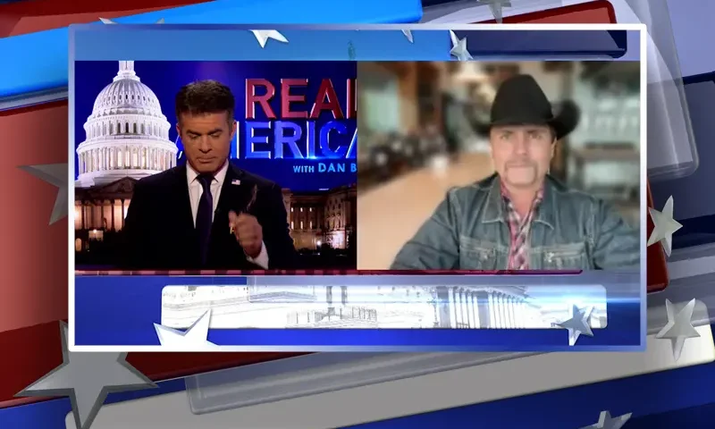 Video still from Real America on One America News Network showing a split screen of the host on the left side, and on the right side is the guest, John Rich.