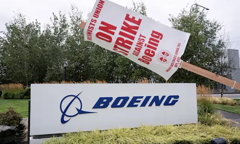 A strike sign hangs from a post near a Boeing sign as Boeing factory workers and supporters gather on a picket line during the third day of a strike near the entrance to a Boeing production facility in Renton, Washington, U.S. September 15, 2024. REUTERS/David Ryder/File Photo