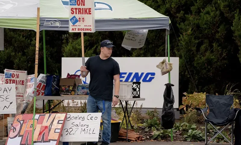 Boeing worker Riley Nelson holds a sign at a picket line near the entrance to a Boeing production facility in Renton, Washington, U.S. October 11, 2024. REUTERS/David Ryder/File Photo