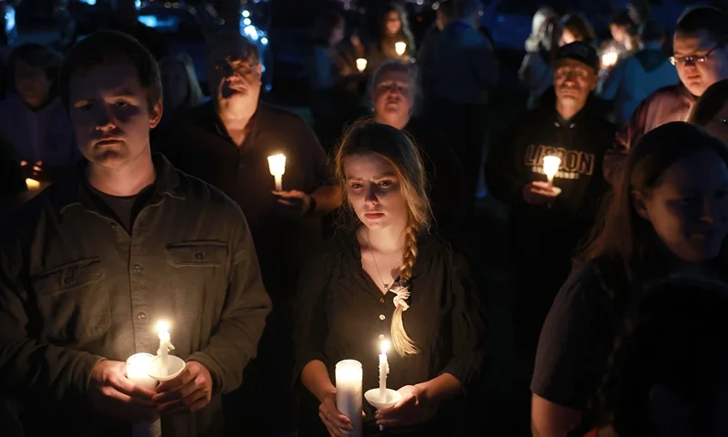 People attend a candlelight vigil to honor the victims of the Lewiston shootings on October 28, 2023 in Lisbon, Maine. Card killed 18 people in a mass shooting at a bowling alley and a restaurant in Lewiston and was found dead in Lisbon. (Photo by Joe Raedle/Getty Images)