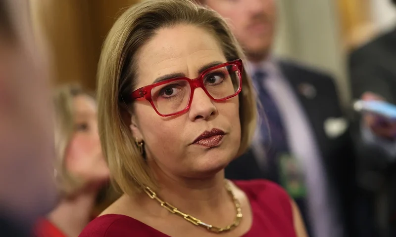 : U.S. Sen. Kyrsten Sinema (I-AZ) speaks to reporters at the U.S. Capitol on February 05, 2024 in Washington, DC. The Senate is working on bringing a bipartisan border security and immigration bill to the floor later this week for a vote. The bill, that also provides funding to Ukraine, Israel and humanitarian aid to Gaza, has received criticism from House Republicans, with Speaker Johnson saying it will be "dead on arrival." (Photo by Kevin Dietsch/Getty Images)