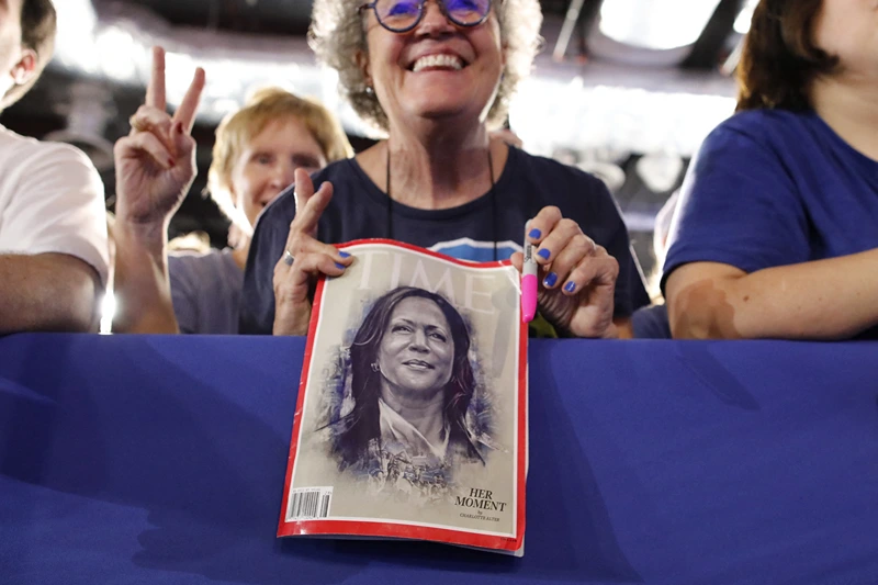 A supporter holds a Time Magazine with US Vice President and Democratic presidential candidate Kamala Harris on the cover at a campaign event at Wilkes University's McHale Athletic Center in Wilkes-Barre, Pennsylvania, September 13, 2024. (Photo by Kena BETANCUR / AFP) (Photo by KENA BETANCUR/AFP via Getty Images)