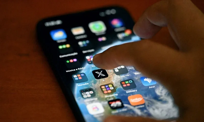 This photo illustration shows the social media platform X (former Twitter) app on a smartphone in Rio de Janeiro, Brazil on September 18, 2024. Brazilian X users reported their surprise after being able to access the platform, suspended in Latin America's largest country by a decision of the supreme court, which is investigating an apparent technical 'instability'. (Photo by Mauro PIMENTEL / AFP) (Photo by MAURO PIMENTEL/AFP via Getty Images)