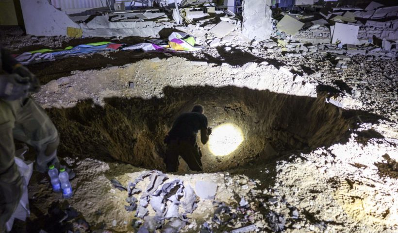 TOPSHOT - Members of Israel's Home Front Command and police forces inspect a crater left by an exploded projectile at a heavily-damaged school building in Israel's southern city of Gedera on October 1, 2024, after Iran launched a barrage of missiles at Israel in response to the killings of Lebanese Hezbollah leader Nasrallah and other Iran-backed militants. Reports said Iran fired between 150 and 200 missiles in the attack, the country's second on Israel after a missile and drone attack in April in response to a deadly Israeli air strike on the Iranian consulate in Damascus. (Photo by Menahem KAHANA / AFP) (Photo by MENAHEM KAHANA/AFP via Getty Images)