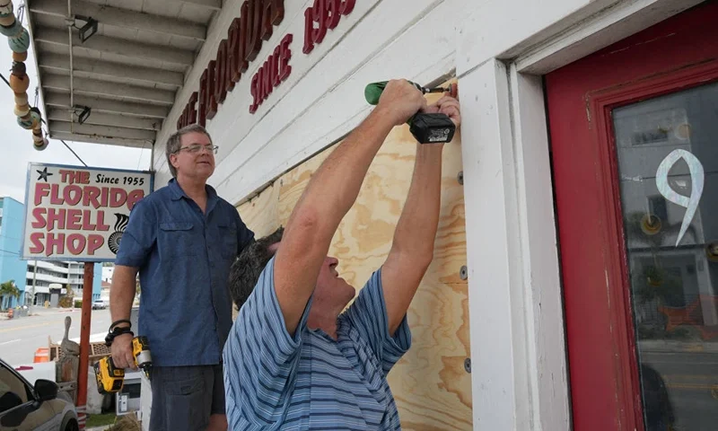 Residents board up a sea shell store ahead of Hurricane Milton's expected landfall in the middle of this week in Treasure Island, Florida on October 7, 2024. Florida's governor has declared a state of emergency on Saturday as forecasters warned that Hurricane Milton is expected to make landfall later this week. (Photo by Bryan R. SMITH / AFP) (Photo by BRYAN R. SMITH/AFP via Getty Images)