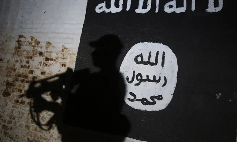 TOPSHOT - A member of the Iraqi forces walks past a mural bearing the logo of the Islamic State (IS) group in a tunnel that was reportedly used as a training centre by the jihadists, on March 1, 2017, in the village of Albu Sayf, on the southern outskirts of Mosul. Iraqi forces launched a major push on February 19 to recapture the west of Mosul from the Islamic State jihadist group, retaking the airport and then advancing north. (Photo by AHMAD AL-RUBAYE / AFP) (Photo by AHMAD AL-RUBAYE/AFP via Getty Images)