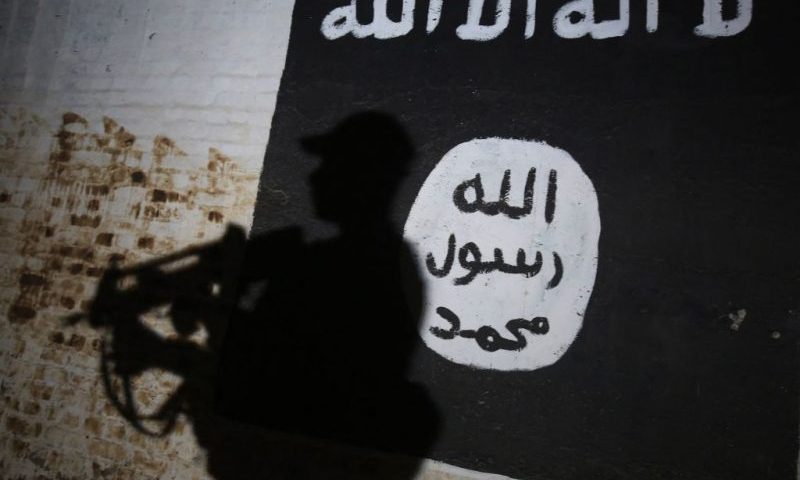 TOPSHOT - A member of the Iraqi forces walks past a mural bearing the logo of the Islamic State (IS) group in a tunnel that was reportedly used as a training centre by the jihadists, on March 1, 2017, in the village of Albu Sayf, on the southern outskirts of Mosul. Iraqi forces launched a major push on February 19 to recapture the west of Mosul from the Islamic State jihadist group, retaking the airport and then advancing north. (Photo by AHMAD AL-RUBAYE / AFP) (Photo by AHMAD AL-RUBAYE/AFP via Getty Images)