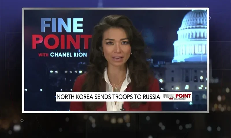 Video still of the host of Fine Point at the desk of their talk show on One America News Network.
