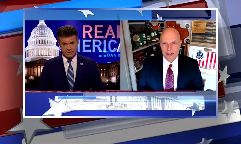 Video still from Real America on One America News Network showing a split screen of the host on the left side, and on the right side is the guest, Ron Vitiello.