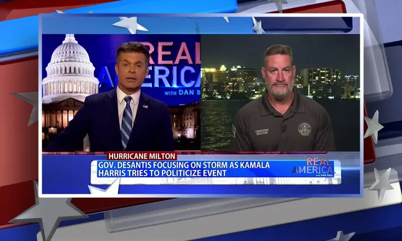 Video still from Real America on One America News Network showing a split screen of the host on the left side, and on the right side is the guest, Rep. Greg Steube.