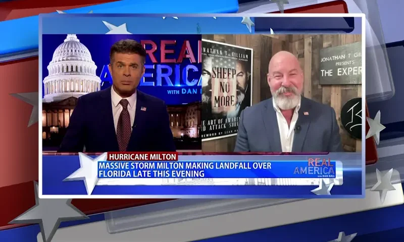 Video still from Real America on One America News Network showing a split screen of the host on the left side, and on the right side is the guest, Jonathan Gilliam.