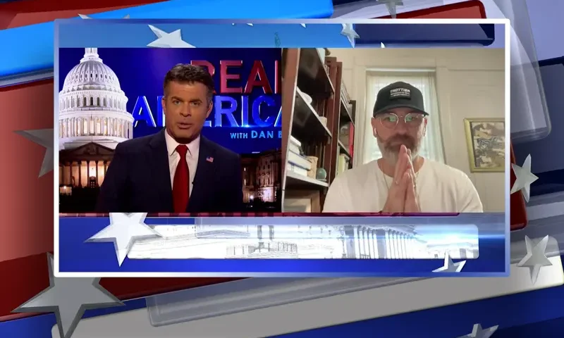Video still from Real America on One America News Network showing a split screen of the host on the left side, and on the right side is the guest, Chris Martini.