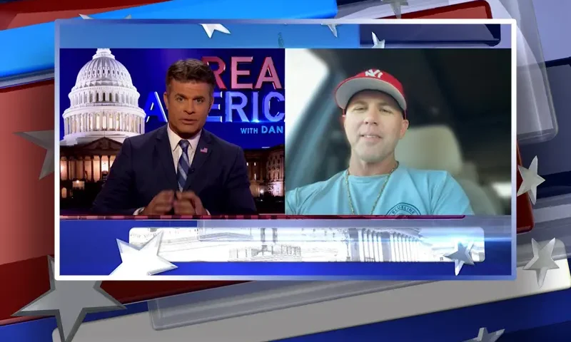 Video still from Real America on One America News Network showing a split screen of the host on the left side, and on the right side is the guest, John Rourke.