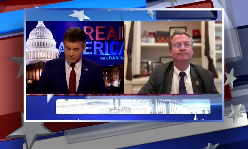 Video still from Real America on One America News Network showing a split screen of the host on the left side, and on the right side is the guest, Rep. Tim Burchett.