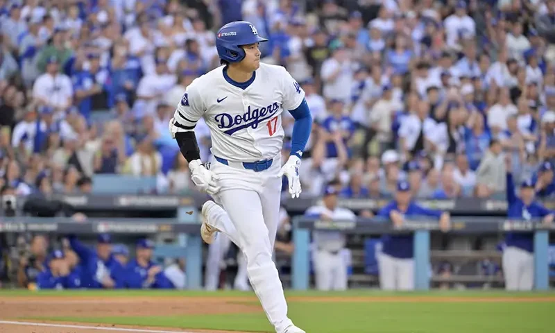 Los Angeles Dodgers designated hitter Shohei Ohtani (17) runs to first after hitting a single in the first inning against the New York Mets during game six of the NLCS for the 2024 MLB playoffs at Dodger Stadium. Mandatory Credit: Jayne Kamin-Oncea-Imagn Images