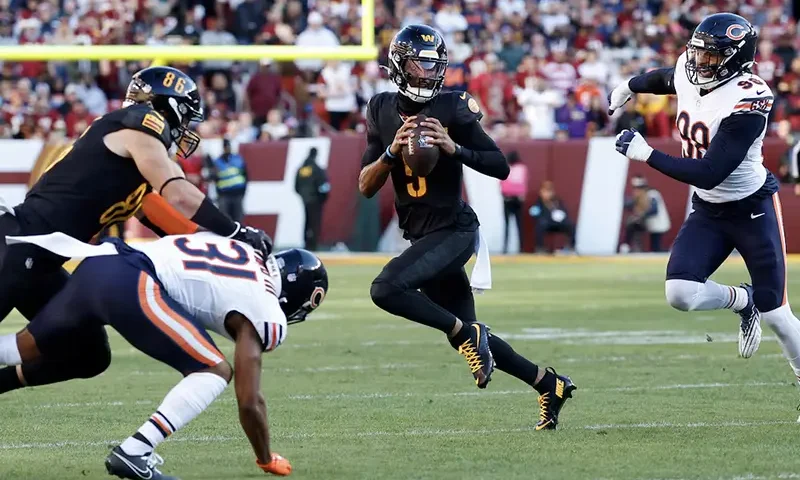 Washington Commanders quarterback Jayden Daniels (5) runs with the ball as Chicago Bears defensive end Montez Sweat (98)chases during the first quarter at Northwest Stadium. Mandatory Credit: Geoff Burke-Imagn Images