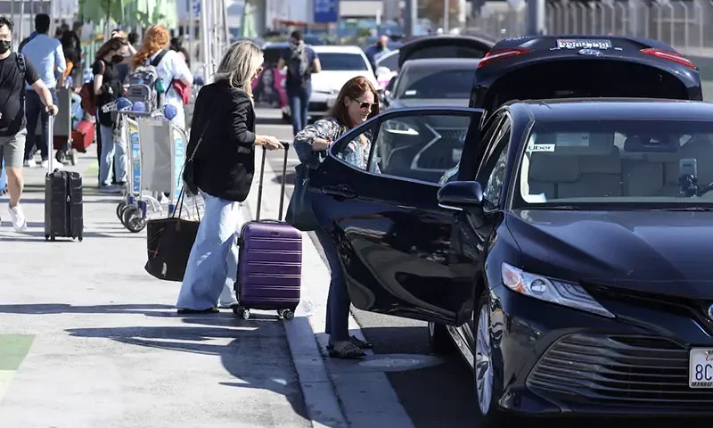 Passengers board Uber ride-share cars after arriving at Los Angeles International Airport (LAX) in Los Angeles, California, U.S. July 10, 2022. REUTERS/David Swanson/File Photo