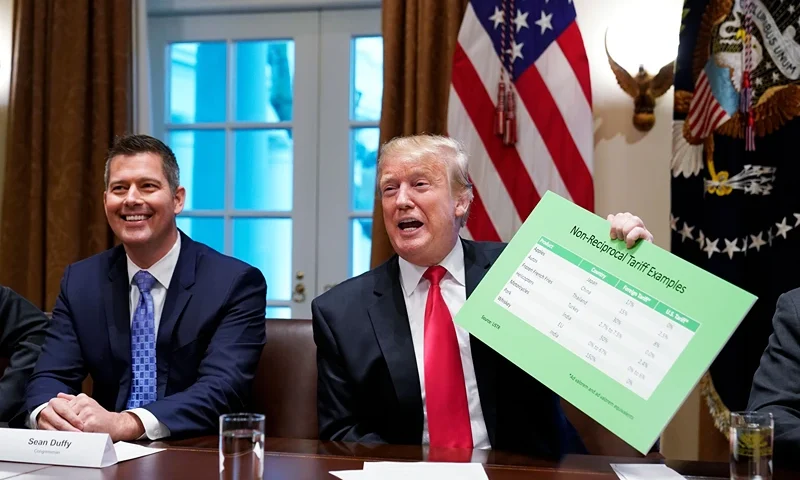 US President Donald Trump, with US Congressman Sean Duffy (L), holds a tariff table as he speaks in the Cabinet Room of the White House on January 24, 2019. - Trump spoke about the unfair trade practices at play in the world. (Photo by MANDEL NGAN / AFP) (Photo credit should read MANDEL NGAN/AFP via Getty Images)