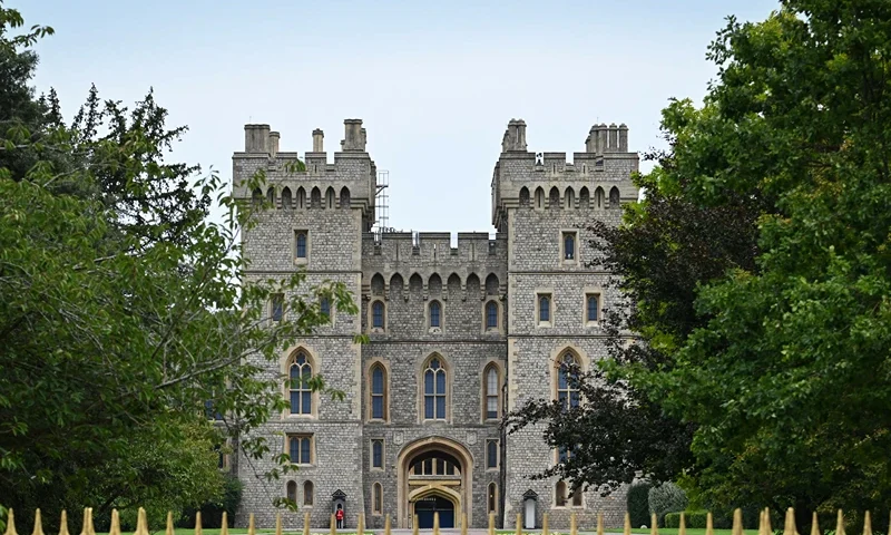 TOPSHOT - Members of the public gather outside Windsor Castle, west of London, on September 13, 2022, following the death of Queen Elizabeth II on September 8. Mourners in Edinburgh, some in tears, filed past the coffin of Queen Elizabeth II through the night, before new king Charles III travels to Northern Ireland on September 13, 2022 and the monarch's coffin returns to London. (Photo by Sébastien BOZON / AFP) (Photo by SEBASTIEN BOZON/AFP via Getty Images)