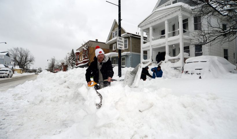 BUFFALO, NY - DECEMBER 27: Luke Bennett helps to clear heavy snow for his neighbors along South Park Avenue on December 27, 2022 in Buffalo, New York. The historic winter storm Elliott dumped up to four feet of snow, leaving thousands without power and at least 28 confirmed dead in the city of Buffalo and the surrounding suburbs. (Photo by John Normile/Getty Images)