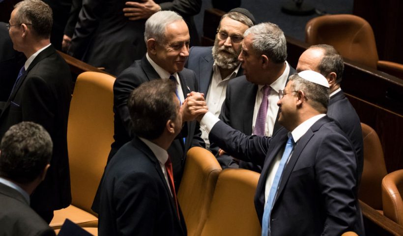 JERUSALEM, ISRAEL - DECEMBER 29: Israeli Prime Minister Benjamin Netanyahu and Minister of National Security Itamar Ben Gvir react after sworn in at the Israeli parliament during a new government sworn in discussion at the Israeli parliament on December 29, 2022 in Jerusalem, Israel. Conservative Benjamin Netanyahu and a bloc of nationalist and religious parties won a clear election victory last month and will be sworn in as government to the Knesset today. This completes Netenyahu's political comeback with a record sixth term in office. (Photo by Amir Levy/Getty Images)