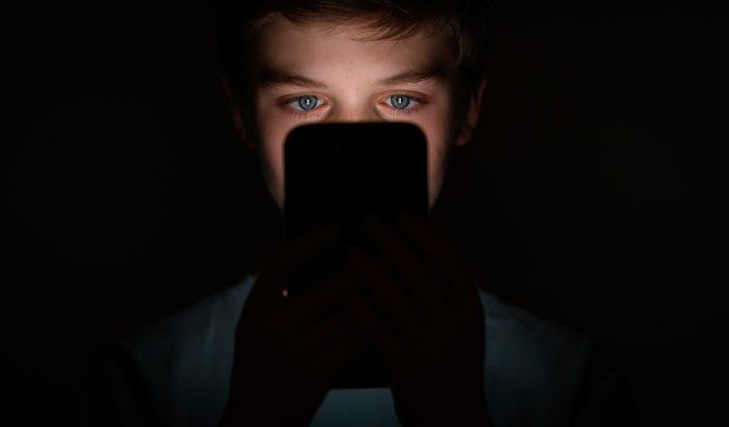 In this photo illustration, a teenage child looks at the screen of a mobile phone on January 17, 2023 in London, England. The 'Online Safety' Bill aims to introduce new rules for companies which host user-generated content, and for search engines, which will have tailored duties focussed on minimising the presentation of harmful search results to vulnerable users. Content that platforms will need to remove includes child sexual abuse material, revenge pornography, selling illegal drugs or weapons, and terrorism. (Photo by Leon Neal/Getty Images)