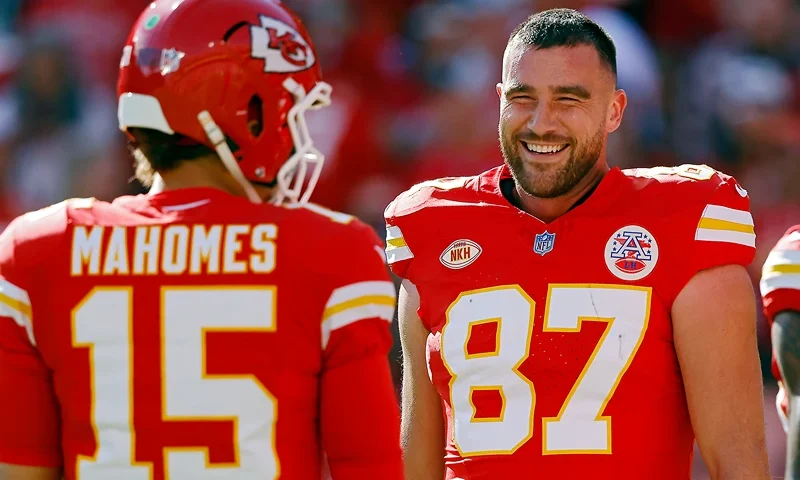KANSAS CITY, MISSOURI - OCTOBER 22: Travis Kelce #87 and Patrick Mahomes #15 of the Kansas City Chiefs talk before the game against the Los Angeles Chargers at GEHA Field at Arrowhead Stadium on October 22, 2023 in Kansas City, Missouri. (Photo by David Eulitt/Getty Images)