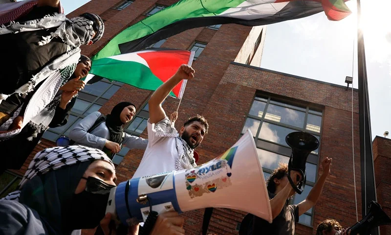 WASHINGTON, DC - MAY 02: Pro-Palestinian demonstrators use a large Palestinian flag to block the doors to Bell Hall as they rally on the campus of George Washington University on May 02, 2024 in Washington, DC. Pro-Palestinian encampments have sprung up at college campuses around the country with some protestors calling for schools to divest from Israeli interests amid the ongoing war in Gaza. (Photo by Chip Somodevilla/Getty Images)