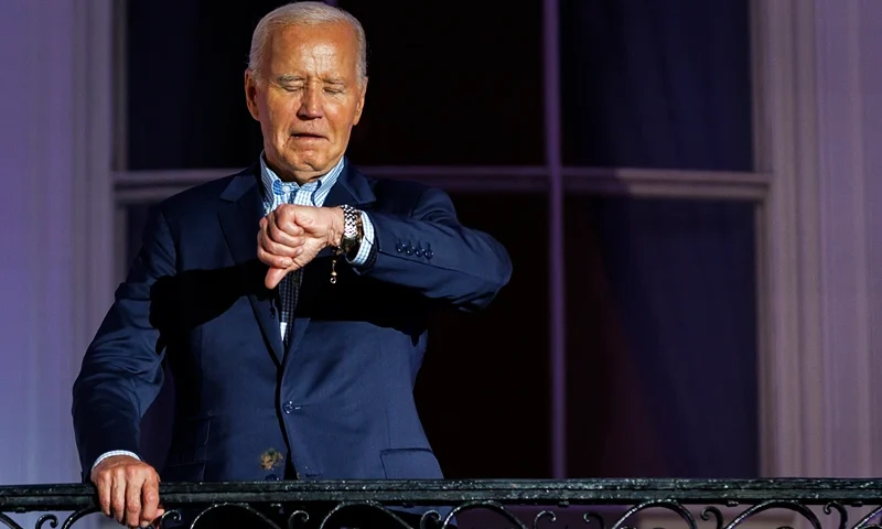 WASHINGTON, DC - JULY 04: President Joe Biden checks his watch as he steps out onto the balcony of the White House to view the fireworks over the National Mall during a 4th of July event on the South Lawn of the White House on July 4, 2024 in Washington, DC. The President is hosting the Independence Day event for members of the military and their families. (Photo by Samuel Corum/Getty Images)