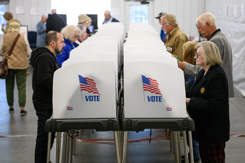 HENDERSONVILLE, NORTH CAROLINA - OCTOBER 17: Voters make selections at their voting booths inside an early voting site on October 17, 2024 in Hendersonville, North Carolina. Several counties effected by Hurricane Helene saw a large turnout of residents for the first day of early voting in Western North Carolina. (Photo by Melissa Sue Gerrits/Getty Images)