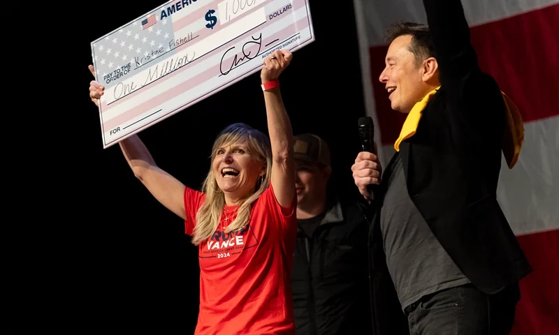 PITTSBURGH, PENNSYLVANIA - OCTOBER 20: SpaceX and Tesla founder Elon Musk awarded Kristine Fishell with a $1 million check during the town hall at the Roxain Theater on October 20, 2024 in Pittsburgh, Pennsylvania. Musk has donated more than $75 million to America PAC, which he co-founded with fellow Silicon Valley venture capitalists and tech businessmen to support Republican presidential nominee, former U.S. President Donald Trump. (Photo by Michael Swensen/Getty Images)
