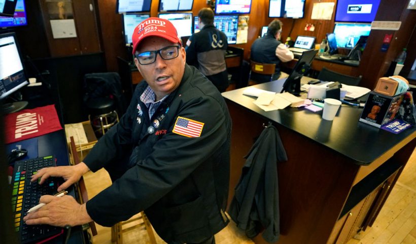 Trader Jonathan Mueller wears a Trump hat as he works on the floor of the New York Stock Exchange (NYSE) at the opening bell on November 6, 2024, in New York City. Wall Street stocks surged in opening trading on Wall Street Wednesday after US voters sent Donald Trump back to the White House and delivered him a Republican Senate. Major indices were up 1.8 percent or more in the early going as hopes about expected tax cuts and regulatory easing more than offset worries about higher tariffs. (Photo by TIMOTHY A. CLARY / AFP) (Photo by TIMOTHY A. CLARY/AFP via Getty Images)