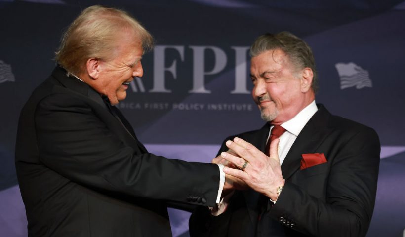 PALM BEACH, FLORIDA - NOVEMBER 14: U.S. President-elect Donald Trump greets actor Sylvester Stallone onstage at the America First Policy Institute Gala held at Mar-a-Lago on November 14, 2024 in Palm Beach, Florida. The annual event supports Grey Team, a nonprofit organization dedicated to preventing military suicide. (Photo by Joe Raedle/Getty Images)