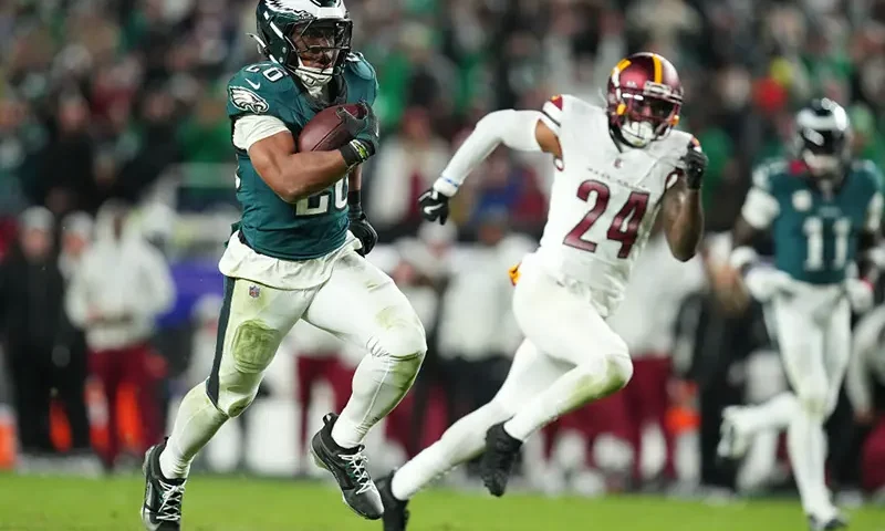 Saquon Barkley #26 of the Philadelphia Eagles runs by Michael Davis #24 of the Washington Commanders on his way to a touchdown during the fourth quarter at Lincoln Financial Field on November 14, 2024 in Philadelphia, Pennsylvania. (Photo by Mitchell Leff/Getty Images)