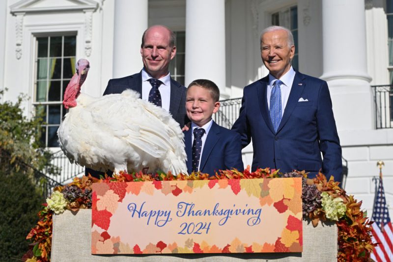 US President Joe Biden pardons Peach, the National Thanksgiving Turkey, alongside Chair of the National Turkey Federation John Zimmerman and his son Grant during an event on the South Lawn of the White House in Washington, DC, on November 25, 2024. The sparing of the wattle adorned gobbling poultry became tradition in 1989 when US President George HW Bush said, "But let me assure you, and this fine tom turkey, that he will not end up on anyone's dinner table, not this guy -- he's granted a Presidential pardon as of right now" and every US President since then has continued the act of mercy. (Photo by ROBERTO SCHMIDT / AFP) (Photo by ROBERTO SCHMIDT/AFP via Getty Images)