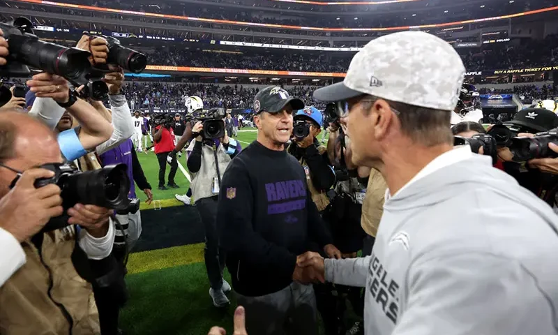 Head coach John Harbaugh (L) of the Baltimore Ravens shakes hands with his brother head coach Jim Harbaugh (R) of the Los Angeles Chargers after the game at SoFi Stadium on November 25, 2024 in Inglewood, California. (Photo by Sean M. Haffey/Getty Images)