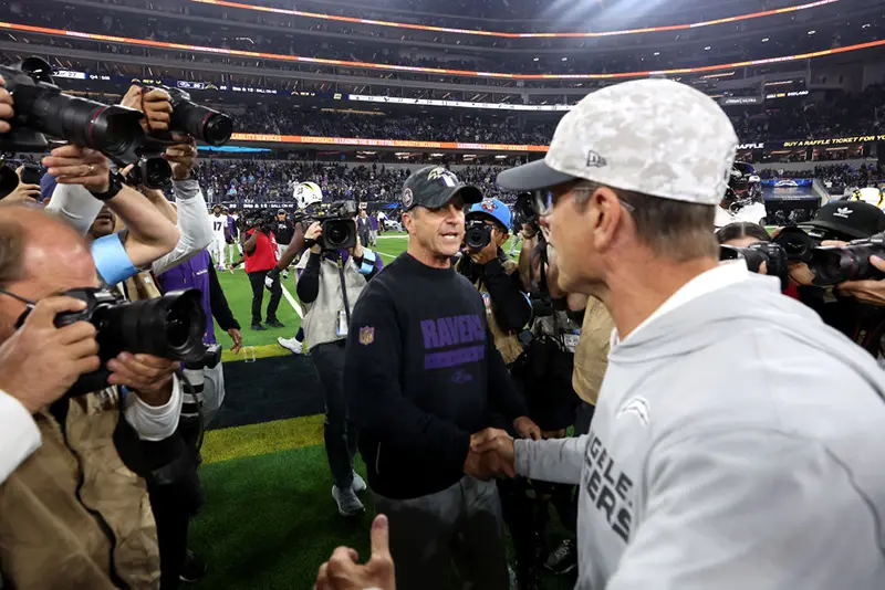 Head coach John Harbaugh (L) of the Baltimore Ravens shakes hands with his brother head coach Jim Harbaugh (R) of the Los Angeles Chargers after the game at SoFi Stadium on November 25, 2024 in Inglewood, California. (Photo by Sean M. Haffey/Getty Images)