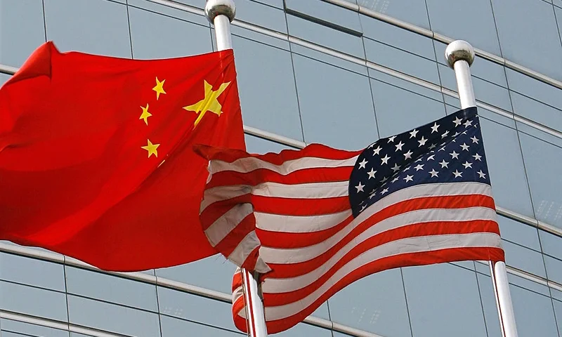 Beijing, CHINA: A US and a Chinese flag wave outside a commercial building in Beijing, 09 July 2007. US Secretary of State Condoleezza Rice 06 July 2007 accused China of flouting the rules of global trade in its headlong economic expansion as the US administration "has not been hesitant" to deploy trade tools against China, including a complaint lodged with the World Trade Organization over copyright piracy. AFP PHOTO/TEH ENG KOON (Photo credit should read TEH ENG KOON/AFP via Getty Images)