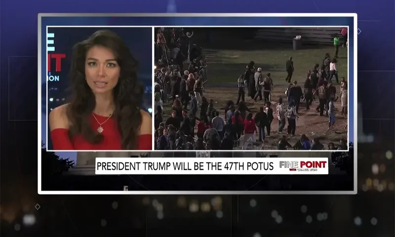 Video still of the host of Fine Point at the desk of their talk show on One America News Network.