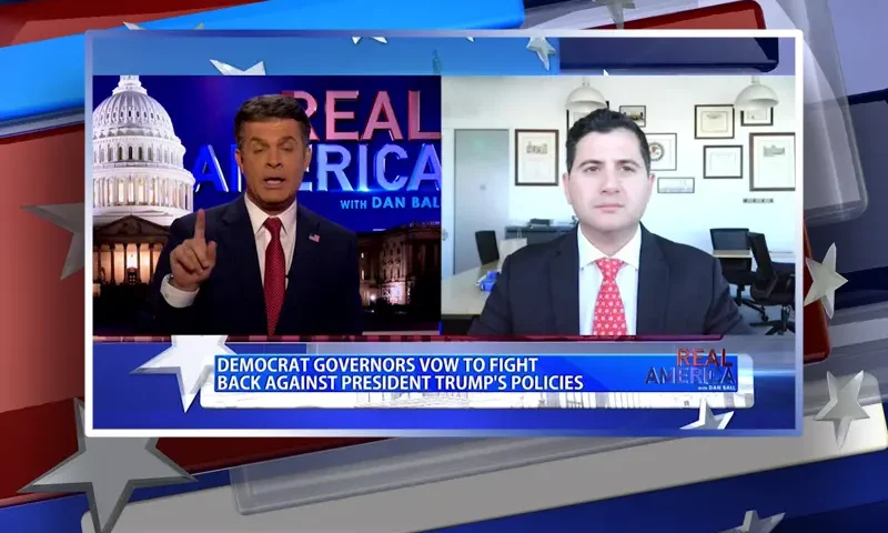 Video still from Real America on One America News Network showing a split screen of the host on the left side, and on the right side is the guest, Bill Essayli.