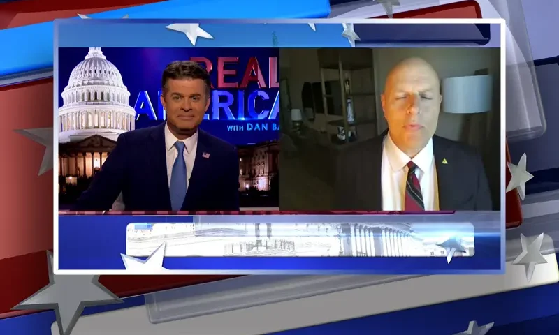 Video still from Real America on One America News Network showing a split screen of the host on the left side, and on the right side is the guest, Ron Vitiello.