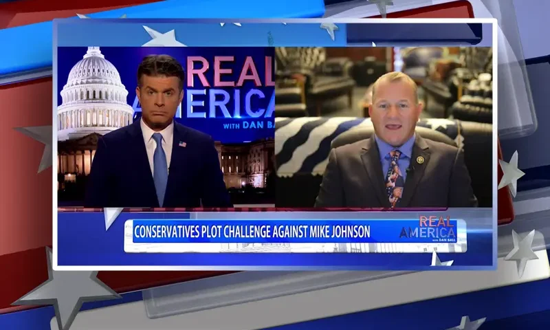 Video still from Real America on One America News Network showing a split screen of the host on the left side, and on the right side is the guest, Rep. Troy Nehls.