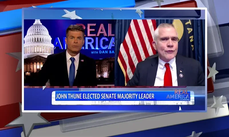 Video still from Real America on One America News Network showing a split screen of the host on the left side, and on the right side is the guest, Rep. Matt Rosendale.