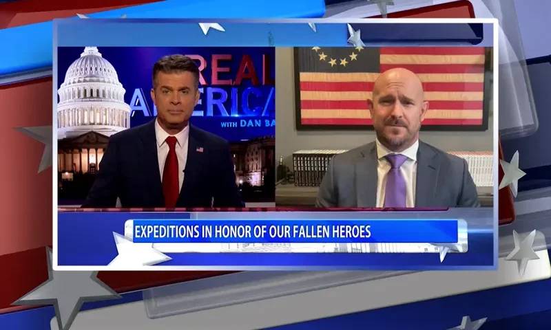 Video still from Real America on One America News Network showing a split screen of the host on the left side, and on the right side is the guest, Mike Sarraille.